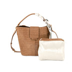 A brown crocodile-embossed bucket handbag with a matching crossbody strap and a small white pouch with brown trim, shown on a plain white background.