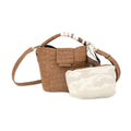 A brown crocodile-embossed leather handbag with a matching crossbody strap and a cream-colored  pouch placed in front of it, set against a plain white background.