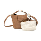 A brown crocodile-embossed leather handbag with a matching crossbody strap and a cream-colored  pouch placed in front of it, set against a plain white background.